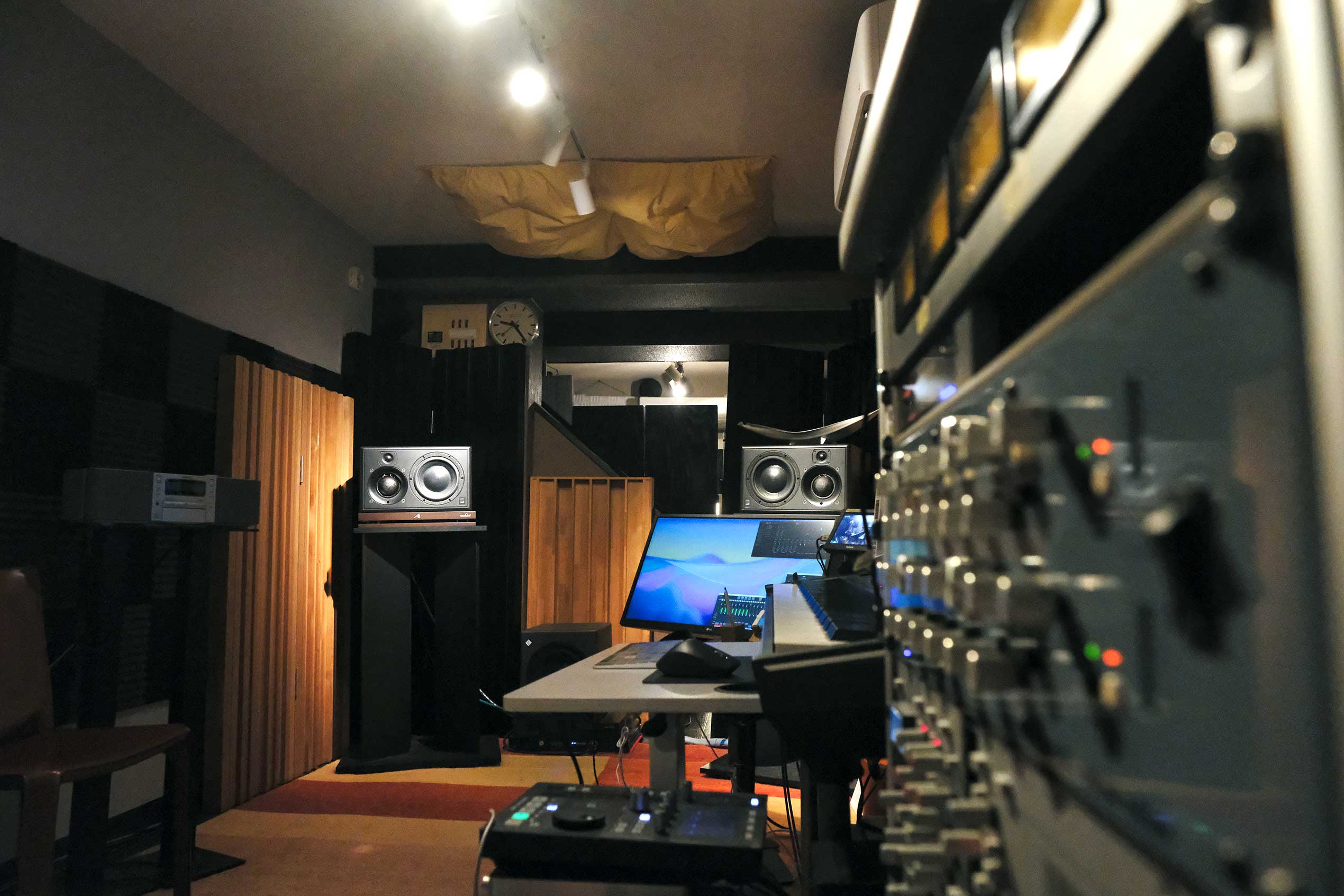 モニターと音響機器が並ぶスタジオのコントロールルーム